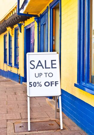 Sale sign outside a vibrant row of shops in Englandの写真素材