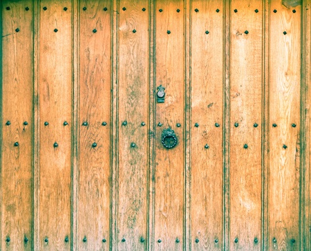 An old wooden door with wrought iron handleの写真素材