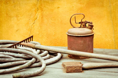 A selection of antique gardening tools on a wooden surface
