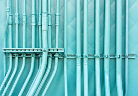 Group of industrial pipes against a wall in striking blue colorの写真素材