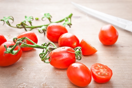 Fresh cherry tomatoes on a chopping boardの写真素材