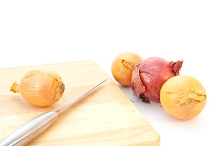 Onions ready for chopping with a metal knife, white backgroundの写真素材