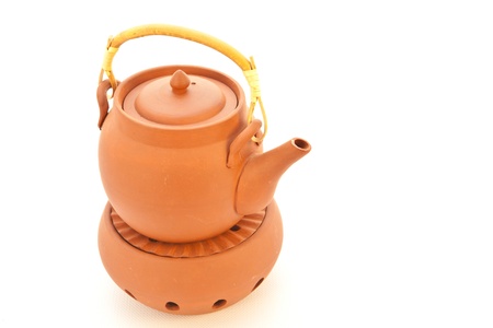 A terracotta teapot on a candle heater on white backgroundの写真素材