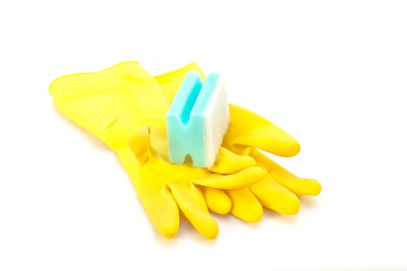 Yellow cleaning gloves and a sponge on white backgroundの写真素材
