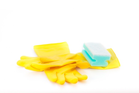 Yellow cleaning gloves and a sponge on white backgroundの写真素材