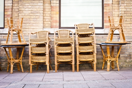 Stacked tables and chairs outside a cafe in a townの写真素材