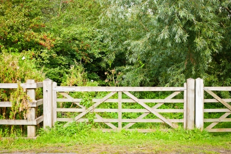 A wooden gate and fence in rural woodlandの写真素材