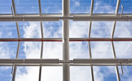 A modern glass roof against a blue skyの写真素材