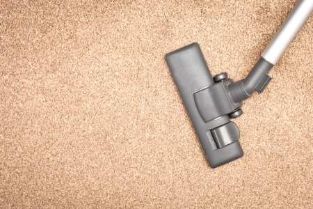 Head of a modern vacuum cleaner on a beige carpetの写真素材