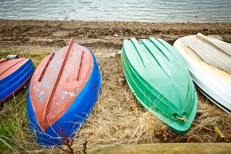 Colorful upturened rowing boats on a shingle beachの写真素材