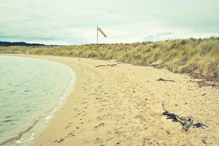 Toned image of a beach in Scotland with a windsock