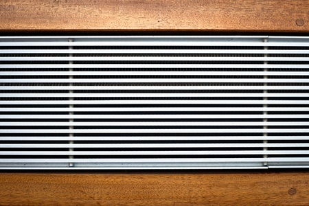 Metal heating unit in a wooden floorの写真素材