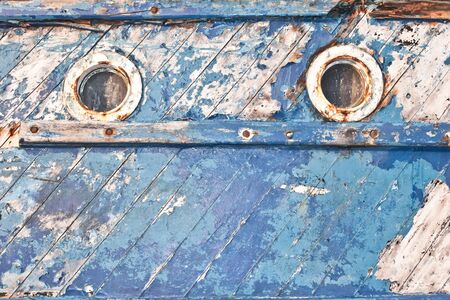 Close up of the portholes on the side of an old fishing boatの写真素材