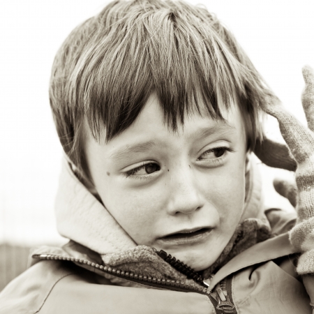 Young boy sad or scared in sepia tonesの写真素材