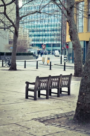 A wooden bench in an urban public spaceの写真素材