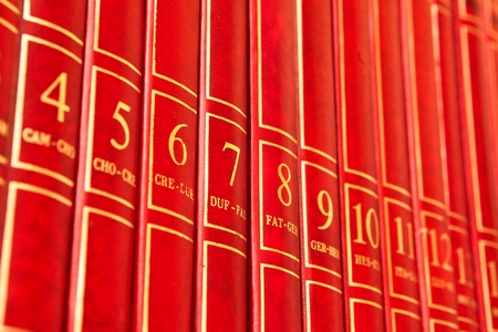 Row of red encyclopedia books on a shelfの写真素材