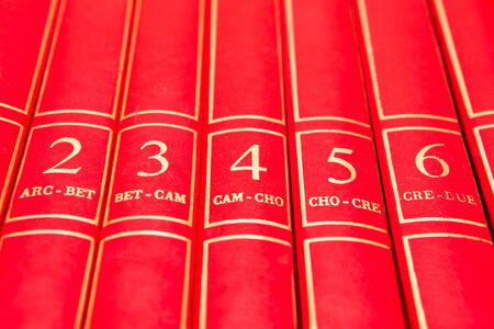 Row of red encyclopedia books on a shelfの写真素材