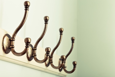 Row of vintage coat hooks on a wooden plaque