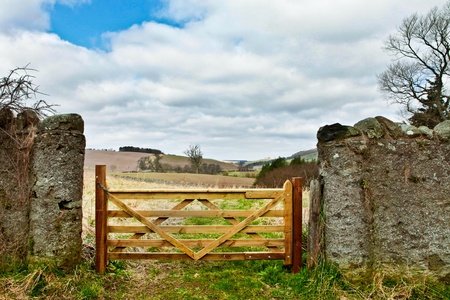 Wooden gate in a stone wall on a farm in Scotland