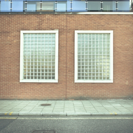 Two glass brick windows in a wall of an urban buildingの写真素材