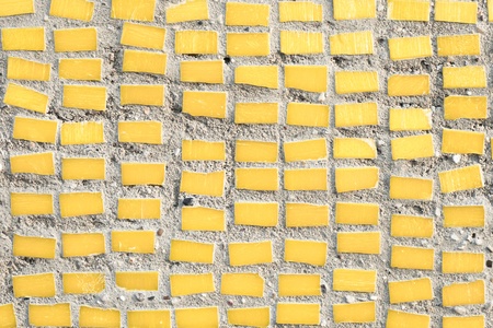 small yellow tiles on a stone surface as a backgroundの写真素材