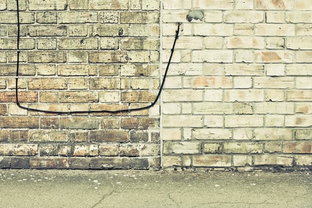 Telephone wire in a brick wall in muted tonesの写真素材