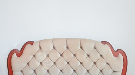 A retro bedstead against a white wall