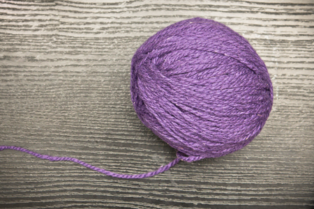 Ball of purple wool on a wooden surfaceの写真素材