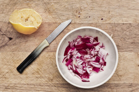 Chopped red onion and lemon on a wooden boardの写真素材