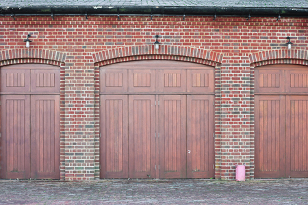 Large wooden doors in a brick buildingの写真素材