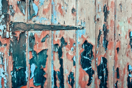 Old wooden door with hinge and peeling paintの写真素材
