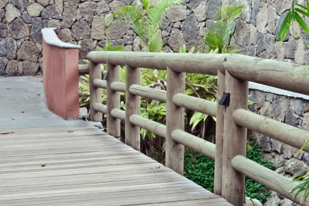Railings of a wooden bridge in a landscaped gardenの写真素材