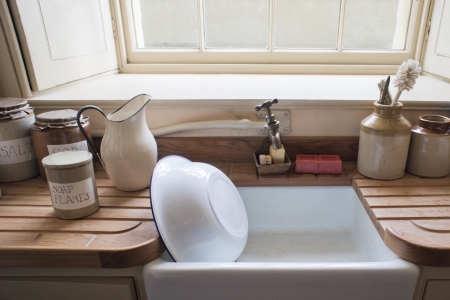 Old fashioned washing up sink with vintage cannisters