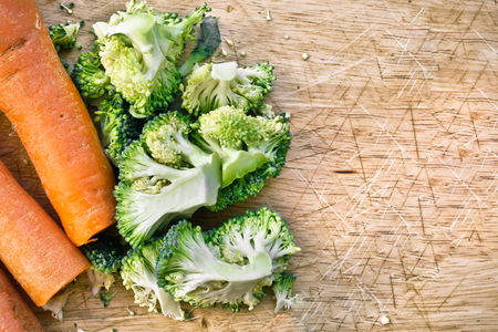 Raw broccoli and carrots on a wooden surface for cuttingの写真素材