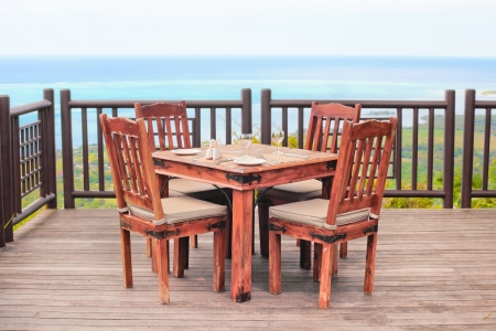 Outside dining table and chairs on a wooden balcony