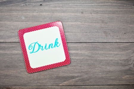 A colorful retro drink coaster on a wooden surfaceの写真素材