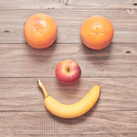 Smiling face made from fruit on a wodden backgroundの写真素材