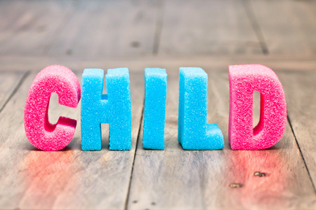 Child spelt out in pink and blue foam lettersの写真素材