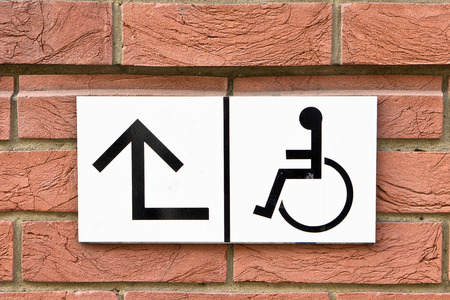 Sign for wheelchair access on a brick wallの写真素材