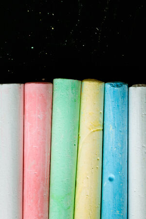 Pieces of chalk against a black chalk boardの写真素材