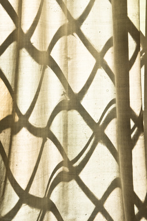 Pattern from a lattice window on a thin curtainの写真素材
