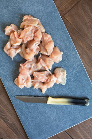 Raw chicken breasts on a blue cutting boardの写真素材