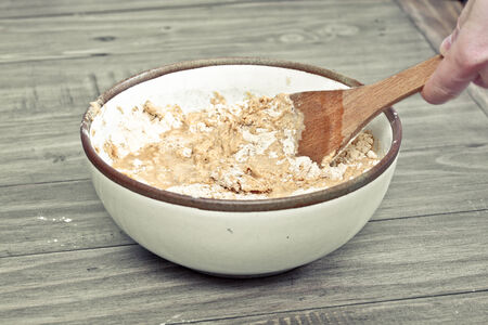 A chef's hands maxing flour and water in a bowl