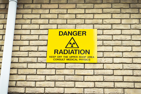 A yellow radiation warning sign on the wall of a hospitalの写真素材