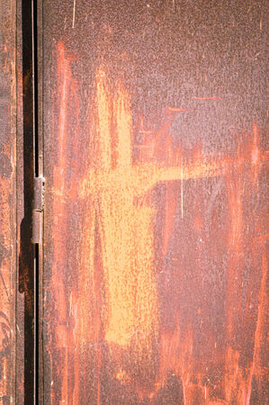 A hinge on a rusty metal door