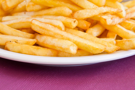 Plate of french fries on a purple table cloth