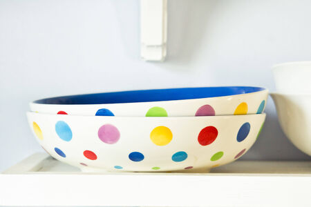 Colorful ceramic bowls on a shelfの写真素材