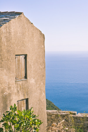 Edge of an old house in Greece with the sea in the backgroundの写真素材