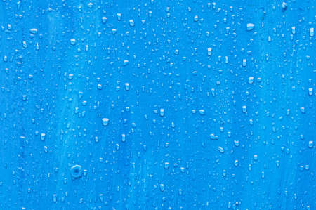 Water drops on a blue wooden surfaceの写真素材