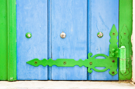 Part of a blue shutter with a green hinge